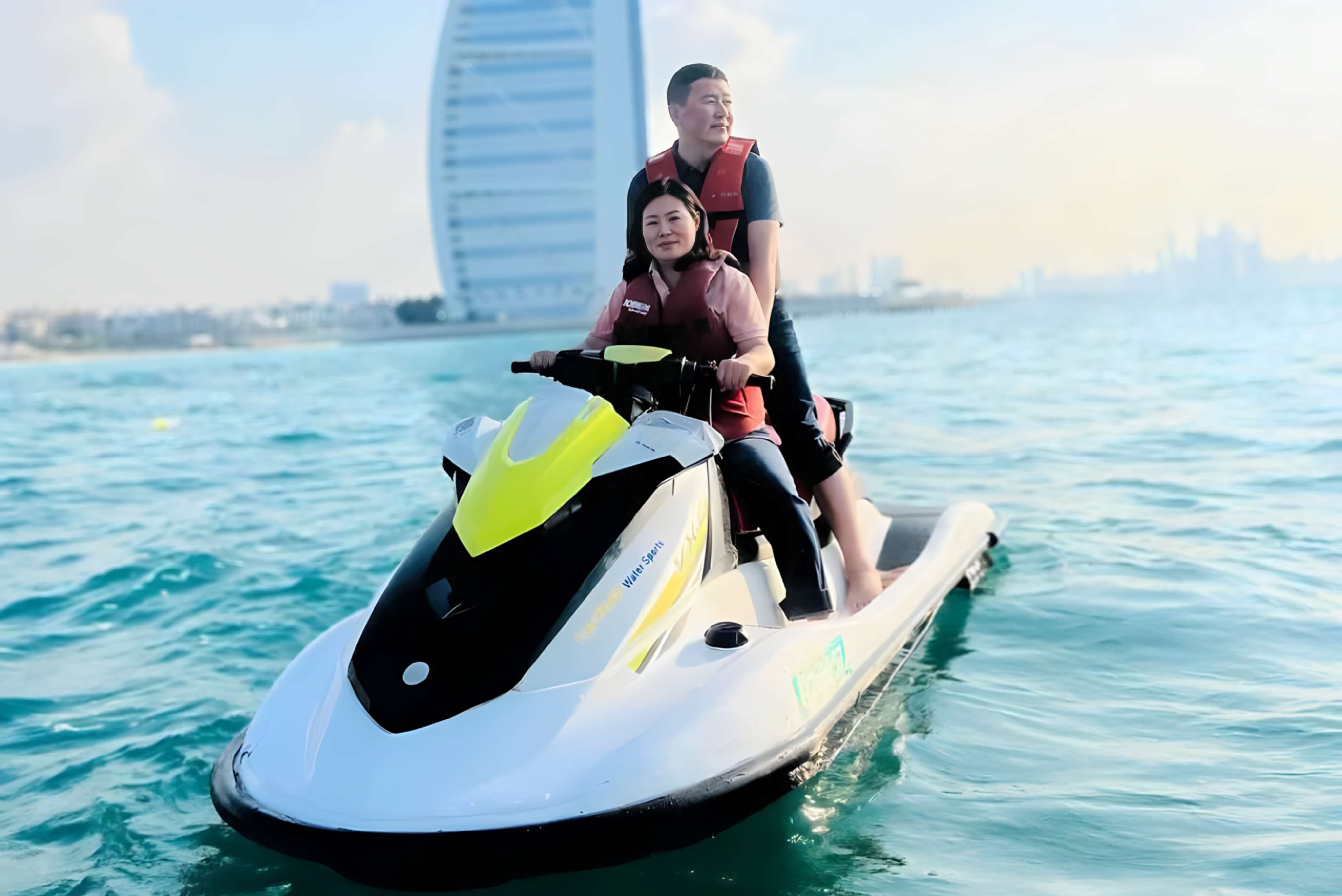 Couple on a jet ski in front of the Burj Al Arab in Dubai