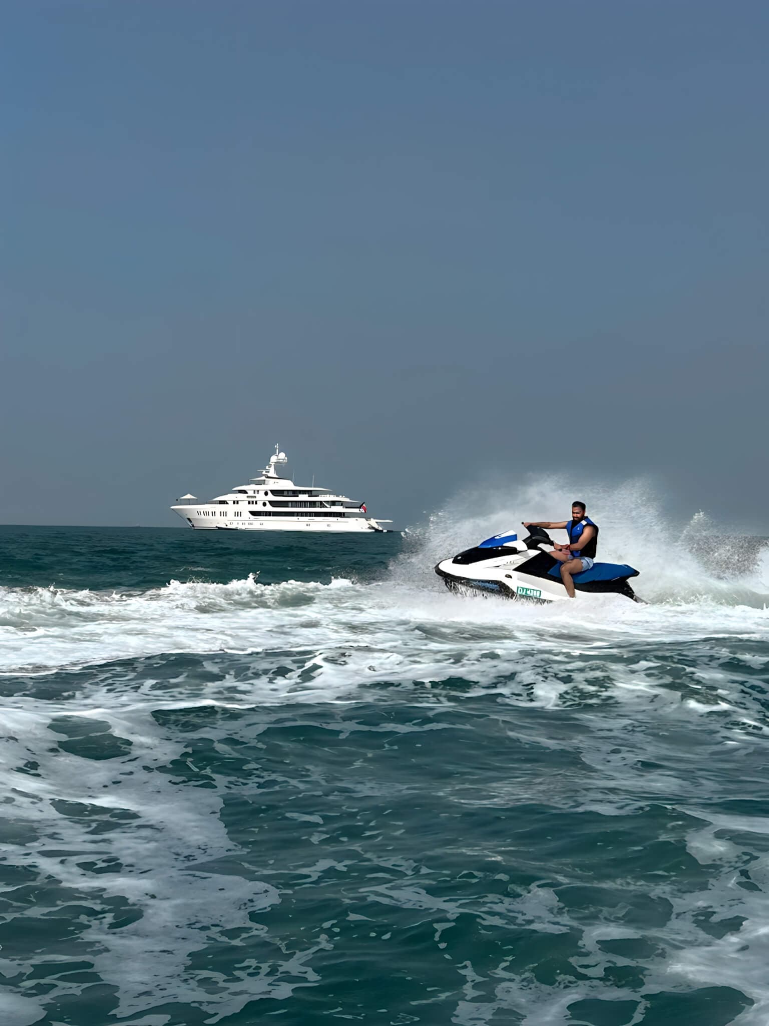 Personal watercraft on the open water near a yacht in Dubai
