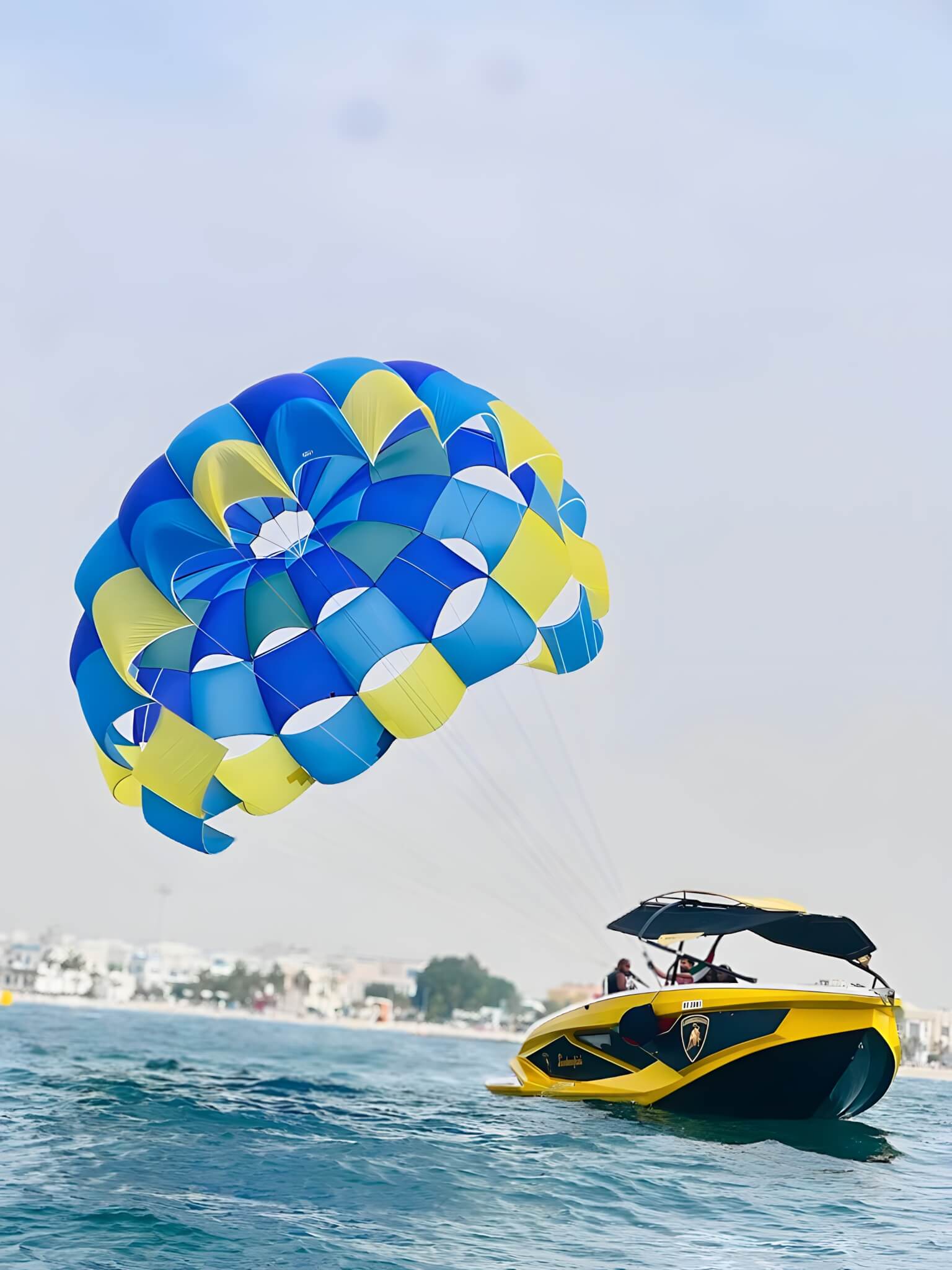Parasailing under a colourful parachute high above the Arabian Gulf off Dubai Marina