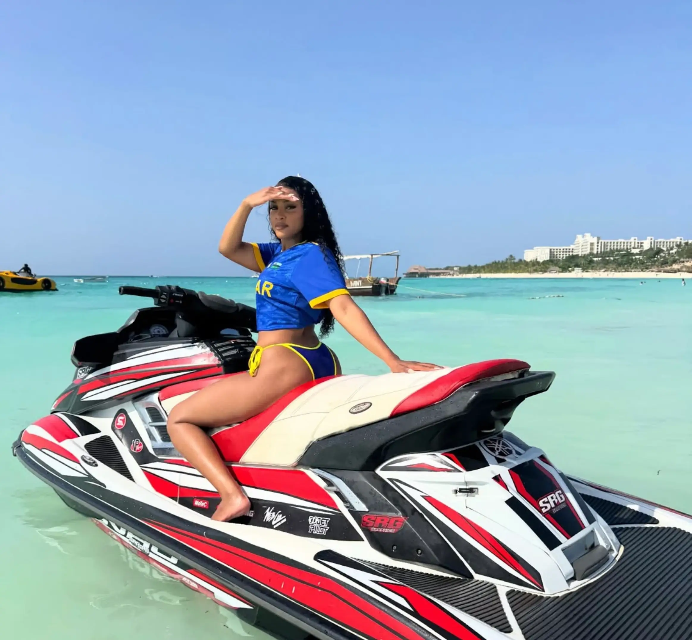 Guest posing on a Trail Blazer jet ski in the turquoise water off Dubai